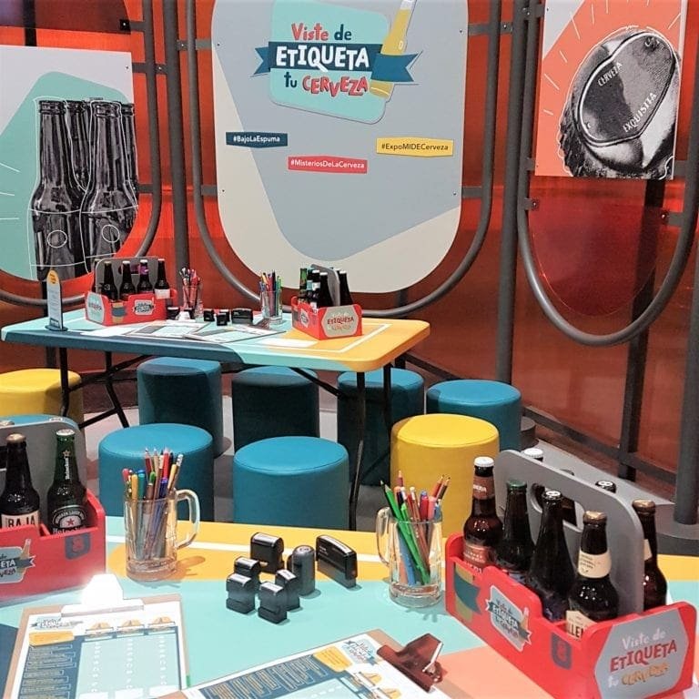 Visitantes diseñando etiquetas de cerveza en la exposición Bajo la Espuma