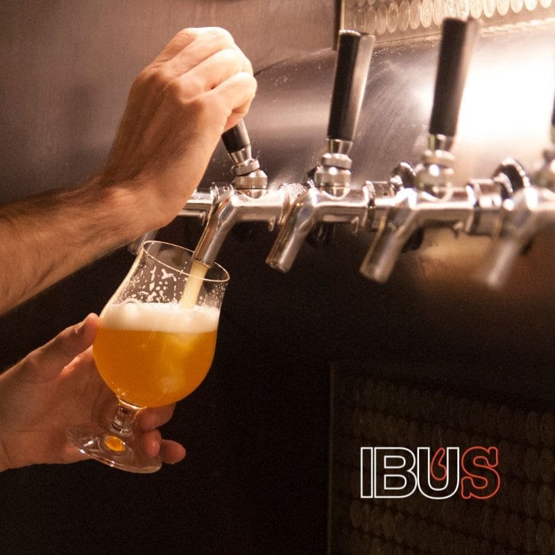 Mano sirviendo cerveza artesanal en una copa
